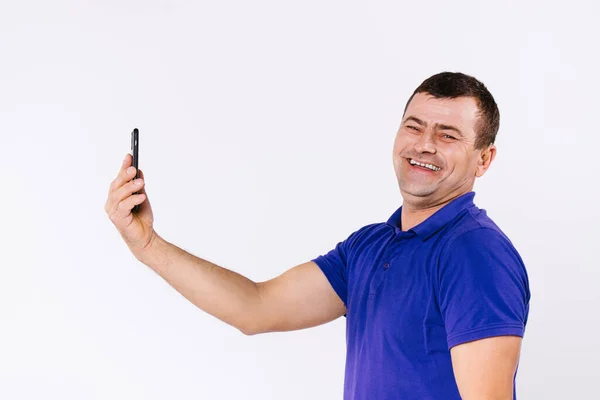 Portrait d'un homme âgé avec une prothèse auditive communiquant par communication vidéo et souriant à la caméra. Fond blanc. — Photo