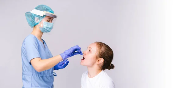 Banner, lang formaat. Een beroepsbeoefenaar in de gezondheidszorg in beschermende kleding neemt een analyse voor een COVID 19-test van een monddoekje. Grijze achtergrond en lege zijruimte. — Stockfoto