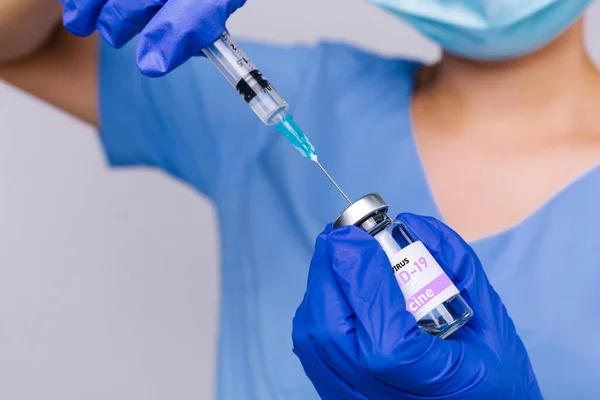 Foto recortada de un trabajador médico que prepara una jeringa con la vacuna covid 19 sobre un fondo gris. Vacunación médica contra el coronavirus — Foto de Stock