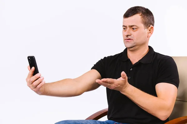 Senior man with hearing aid communicates non-verbally via video call. White background with empty space. — Stock Photo, Image