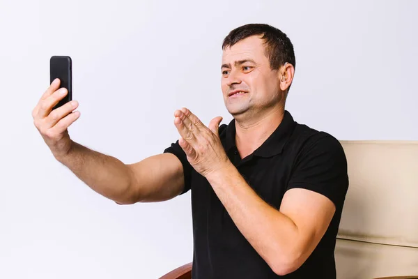 Hörgeschädigter Mann im Bürostuhl kommuniziert per Videokommunikation mittels Gesten, die ein Zeichen der Dankbarkeit zeigen. Weißer Hintergrund. — Stockfoto