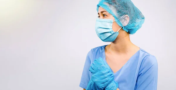 Banner, formato lungo. Foto profilo di un giovane medico in abito protettivo guardando di lato in uno spazio vuoto per la vostra pubblicità. Sfondo bianco. Concetto anti-covid 19. — Foto Stock