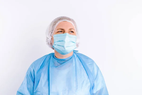 하얀 배경과 빈 공간을 배경으로 하여 의료 장비를 보호하고 있는 선임 여성 의사의 모습. — 스톡 사진