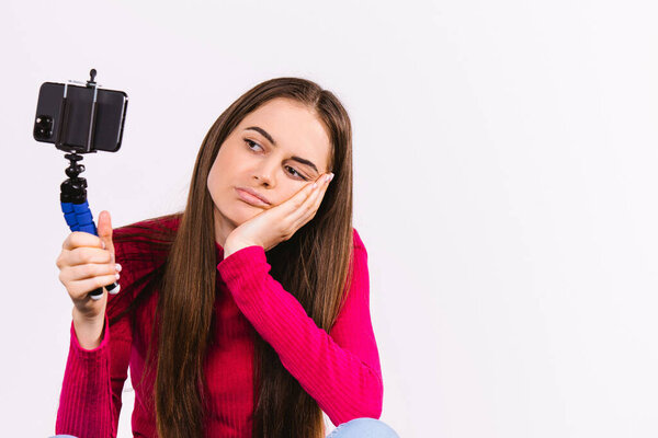 Кавказская блогерша грустит во время прямой трансляции. Несколько новых подписчиков. Белое фоновое пространство для рекламы