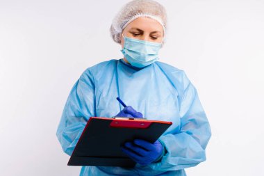 Hasta listesini beyaz arka planda dolduran kovid 19 enfeksiyonuna karşı koruyucu tıbbi ekipman kullanan bir doktor..