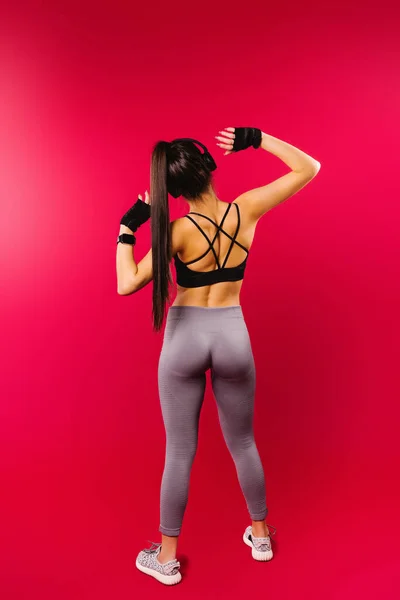 Achteraanzicht foto van mooie vrouwelijke hardloper vrouw workout, luisteren naar de muziek met hoofdtelefoon en ontspannen genieten van de sfeer — Stockfoto