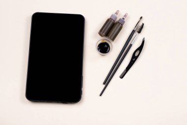 Kına kına seti için boş siyah tablet ekranı, cımbız prosedürü. Video dersi, online moda atölyesi. Bej arka planda cilt bakımı. Yüksek kalite fotoğraf