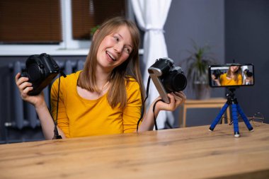 Blogculuk, video blogu ve insanların konsepti - genç kızı kaydeden kamera. Kadın blogcu, iki kameranın video incelemesi: klasik vs modern, ev ofisinde. Yüksek kalite fotoğraf