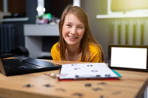 Caucasian teacher sitting in front of laptop. English alphabet on table for practical lessons. Distance learning. Home school education. E-learning perspective. Mock up tablet. High quality photo