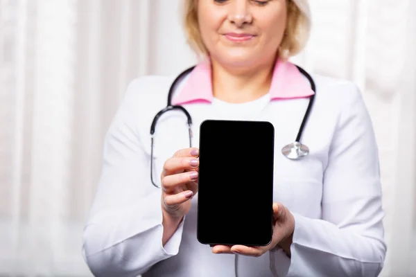 用数字平板电脑拍摄了一位女医生的照片 在摄像机前展示了一个模拟的空屏幕 有选择地关注数字平板电脑 在线医疗咨询 高质量的照片 — 图库照片