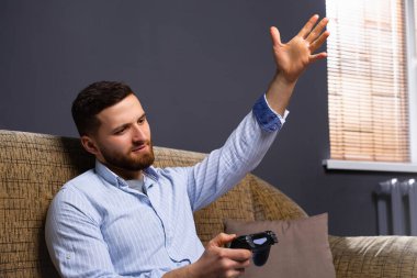 Evinde elinde joystick ile kanepede oturan bir adam. Huysuz adam kaybından dolayı öfkelidir. Zaman geçirmek. Yüksek kalite fotoğraf