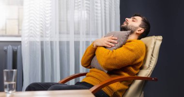 Genç adam rahatlar, gözleri kapalı bir sandalyeye uzanır. Adam sakinleşti. Ofis geçmişinde izole edilmiş. İş molası