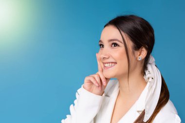 Gülümseyen genç bayan çalışanlar uzaktan bakıp kariyer başarısını hayal ederler. Mutlu iş kadını planları ya da iş yerinde düşleri. Mavi arka planda iş görüşü kavramı