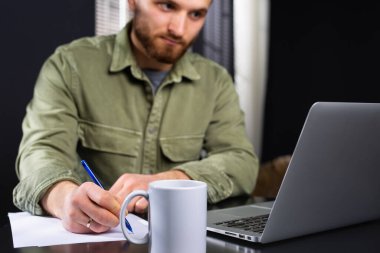 Evden çalışıyor, sıradan bir iş adamı dizüstü bilgisayar kullanıyor, deftere bir fincan çayla yazı yazıyor. Bilgisayar uygulaması üzerinden e-kitap okuyan öğrenci, çevrimiçi ders çalışıyor