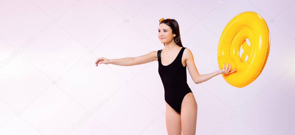 Banner, long format. Caucasian girl aspirator in a black swimsuit and an inflatable lifebuoy stretches out her hand in front. Neon background with space.
