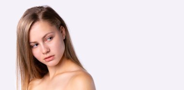 Banner, uzun format. Yanlara bakan uzun sarı saçlı bir kızın portresi. Gri arkaplanda doğal güzellik kavramı.