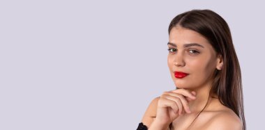 Uzun parlak saçlı esmer kız. Saç stili ve kırmızı dudaklı güzel bir manken. Genç ve güzel bir kadın kamerada sana bakıyor. Banner - tanıtım ve bilgi için grinin uzun biçimi