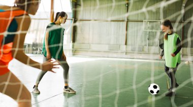 Maç sırasında büyük profesyonel arenada bayan oyuncular. İçeriden fotoğraf, futbol eğitimi. Genç bayan futbolcu ya da spor giyimli futbolcu gol için topa vuruyor. Sağlıklı yaşam tarzı, hobi.