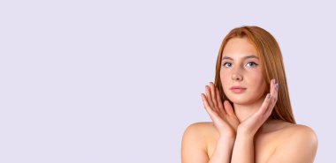 Banner, uzun format. Kadın doğal güzellik portresi. Deri ve vücut bakımı, spa konsepti. Kızıl saçlı, güzel bir kız. Gri arka planda kameraya bakıyor. Reklamlar için bolca yeri var.