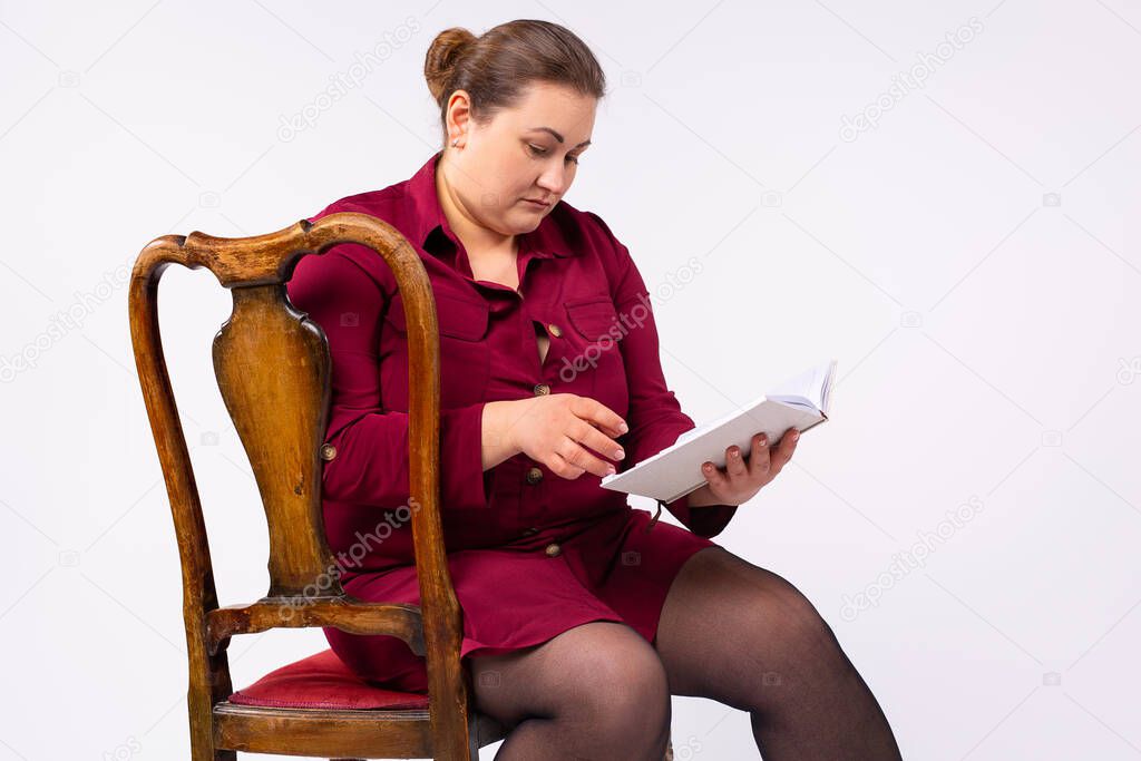 Serious american caucasian businesswoman reading diary, planning business meeting, focused employee, manager writing to schedule meeting event, sitting chair, student writing notes. High quality photo