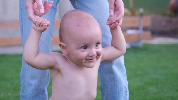 Little baby smiling making his first steps holding on to his mom hands and he is very happy of this day. — Αρχείο Βίντεο