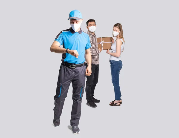 Delivery man employee in blue uniform and face mask delivered the package and he is in a hurry to deliver another goods. — Φωτογραφία Αρχείου