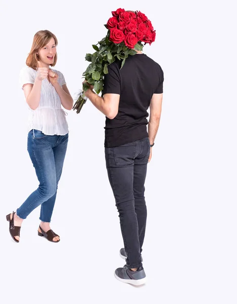 Yakışıklı kız erkek arkadaşının en sevdiği çiçeklerden güzel bir buket taşıdığını görmekten memnun.. — Stok fotoğraf