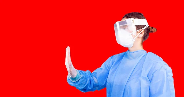 Γυναίκα που φοράει ιατρική στολή με γάντια και προστατευτική πλαστική μάσκα που δείχνει με το χέρι της stop coronavirus. — Φωτογραφία Αρχείου