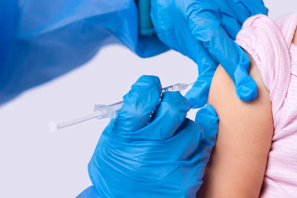 Foto recortada de un médico con guantes de goma haciendo la vacunación a una niña en la clínica moderna contra el coronavirus. — Foto de Stock