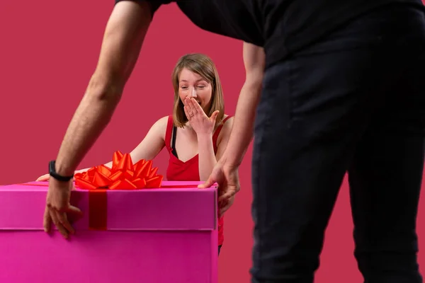 Mutlu, hoş bir kadın, üzerinde fiyonk olan büyük kırmızı bir hediye kutusunu görünce şaşırarak ağzını kapadı.. — Stok fotoğraf