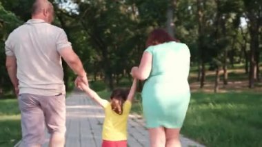 Parkta el ele tutuşup kızlarını büyüten sevimli bir ailenin arka plan videosu..