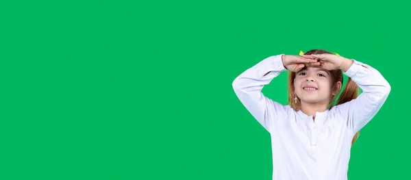 Menina menina em branco t-shirt posando isolado no estúdio segurando a mão na testa olhando para longe distância — Fotografia de Stock