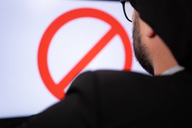 Bilgisayarda oturması yasaklanan Müslüman hacker 'ın yakın portresi.