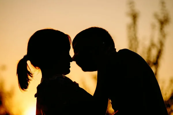 Πλάγια άποψη πορτρέτο του ένα καταπληκτικό νεαρό ζευγάρι αγκαλιάζει και φιλιά κατά το ηλιοβασίλεμα έξω, ενώ το περπάτημα στο δρόμο. — Φωτογραφία Αρχείου