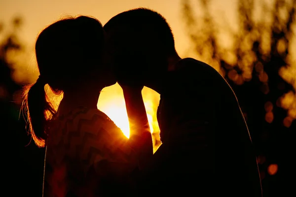 한 젊고 아름다운 부부가 여름 저녁해 가질 때 키스하는 모습이 담긴 측면 사진, 낭만적 인 데이트를 하는 모습. — 스톡 사진