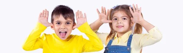 Banner, formato largo. Dos niños niño y niña divirtiéndose delante de la cámara, haciendo muecas y el niño mostrando su lengua. —  Fotos de Stock