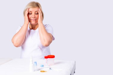 Sarışın ve çekici kadın şaşırdı ve endişelendi. Kafasını tutup yakınındaki masada duran test kavanozlarına baktı..