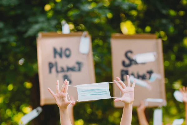 Lidé držící prapor Neexistuje žádná planeta B a Save Planet, bojující za čistotu přírody, protestující proti znečištění a globálnímu oteplování házející lékařské masky nahoru. — Stock fotografie