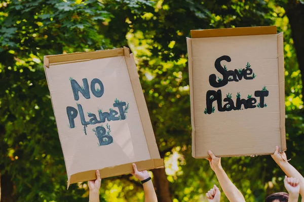 Großaufnahme Foto von zwei Pappbannern mit der Aufschrift zur Unterstützung unseres Planeten, die gegen Umweltverschmutzung und globale Erwärmung protestieren. — Stockfoto