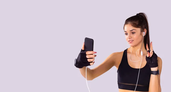 Obrázek úžasné krásné mladé pěkné fitness žena pomocí mobilního telefonu a sluchátek mluvit snadno. — Stock fotografie