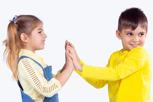 Dos adorables niños tocando con las palmas de las manos unidas y el niño es vacila chica, giró la cabeza a la izquierda. — Foto de Stock