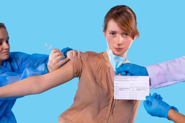 Женщина-врач кладет вакцину в плечо молодой девушки в защитных перчатках, после того, как девушка получает паспорт вакцины. — стоковое фото