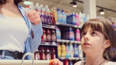 Kız zıplar ve annesini çeker dükkandan şeker almasını ister ve ona tatlı bölümünü gösterir, oraya gitmeleri gerekir..