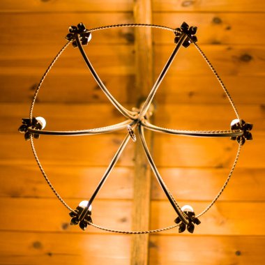 Ahşap arka planda altı ampullü tavan lambası..