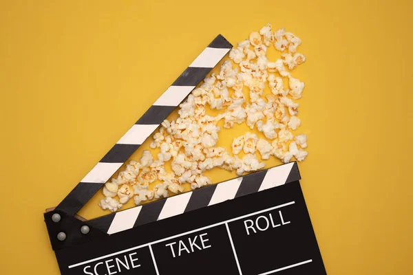 Sarı arka planda film ve TV el çırpması ve ortasında patlamış mısır.