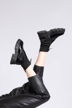 Deri pantolon ve çizme giymiş, bacakları ters dönmüş, tanınmayan bir kadın..