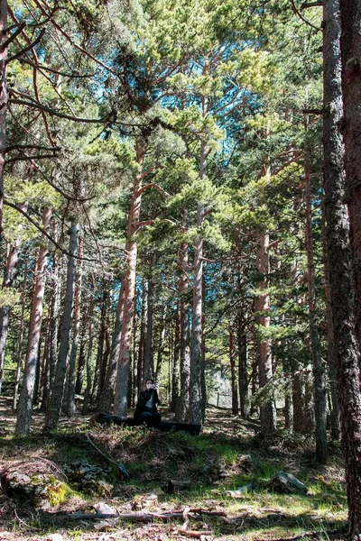 Ormanda otururken maske takan genç bir kadın..