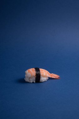 Mavi arka planda karides nigiri suşi