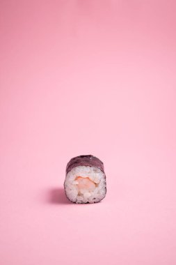 Pembe arka planda karidesli suşi.