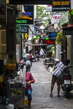 Ho Chi Minh City, Vietnam: 02 / 06 / 2020: sayısız otel, bar ve dükkan tabelasıyla dolu ana caddenin renkli perspektifi, insan ve motosikletle dolu